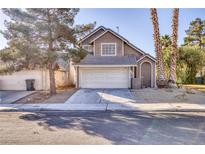 Two-story house with attached garage and landscaping at 1702 La Cruz Dr, Henderson, NV 89014