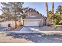 Two-story house with attached garage and desert landscaping at 1702 La Cruz Dr, Henderson, NV 89014