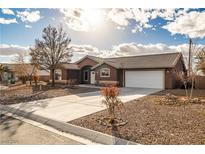 Charming single-story home featuring a two-car garage, desert landscaping, and a concrete driveway at 210 Bristle Cone, Pahrump, NV 89048