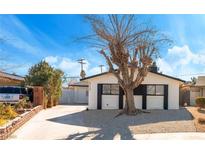 White single story home with black accents, landscaped yard, and driveway at 2113 La Harve Dr, Las Vegas, NV 89106