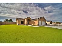 Charming single-story home with a well-manicured lawn, a two car garage, and desert landscaping at 360 S Blagg Rd, Pahrump, NV 89048