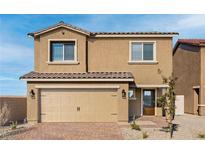 Two-story house with tan exterior, two-car garage, and landscaped front yard at 4219 Gold Desert St, North Las Vegas, NV 89032