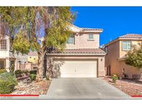 Two story house featuring a two car garage, landscaping, and a red tiled roof at 9328 Freedom Heights Ave, Las Vegas, NV 89149