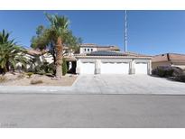 Two-story house with three-car garage, solar panels, and desert landscaping at 1306 Big Tree Ave, North Las Vegas, NV 89031