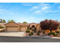 Single-story house with three-car garage,landscaped front yard, and neutral color scheme at 2563 Collinsville Dr, Henderson, NV 89052