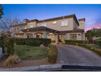 Elegant two-story home showcasing manicured landscaping and a circular driveway, perfect for curb appeal at 10000 Cresent Mesa Ln, Las Vegas, NV 89145