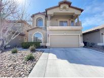 Two-story house with a large garage and landscaped front yard at 7633 Winterthur Ct, Las Vegas, NV 89129