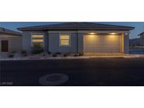 Single-story home with attached garage, landscaping, and nighttime lighting at 888 Market Grove Ln, Las Vegas, NV 89138