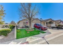 Single-story house with a well-manicured lawn and a red SUV parked in the driveway at 8925 Medicine Wheel Ave, Las Vegas, NV 89143
