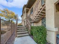 Apartment exterior featuring stairs and a secure fenced entrance, with a well-maintained landscape at 8985 S Durango Dr # 2023, Las Vegas, NV 89113