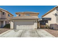 Two-story house with attached garage and landscaped yard at 9961 Mardagen St, Las Vegas, NV 89183