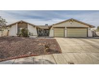 Single-story house with a two-car garage and landscaped front yard at 1688 Crest Ave, Las Vegas, NV 89119