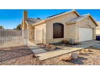 Charming single-story home featuring a gated front yard and a two-car garage with an arched front window at 2177 Bridle Wreath Ln, Las Vegas, NV 89156