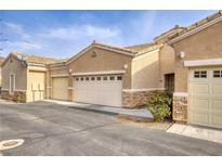 Tan colored stucco home with attached garage and landscaping at 237 Garrett Ln # 2, Boulder City, NV 89005