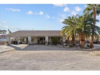 Single-story home with covered porch, palm trees, and a large driveway at 4365 Topaz St, Las Vegas, NV 89121