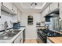 Modern kitchen with white cabinets, butcher block countertops, and stainless steel appliances at 526 Sellers Pl, Henderson, NV 89011