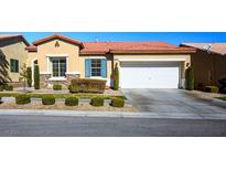 Tan house with tile roof, landscaping, and a two-car garage at 7436 Wagonwheel Ranch Way, Las Vegas, NV 89113