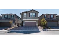 Two-story house with gray siding, brown garage door, and landscaping at 9217 Quartz Hills Ave, Las Vegas, NV 89178