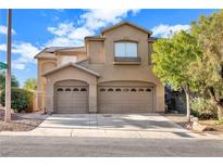 Two-story house with tan siding, two-car garage, and landscaping at 10636 Amblewood Way, Las Vegas, NV 89144