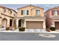 Two-story house with tan exterior, two-car garage, and landscaping at 10636 Tulip Valley Rd, Las Vegas, NV 89179