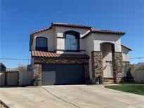 Two-story house with stone accents, a two-car garage, and a well-manicured lawn at 1138 Gainesborough Ct, Henderson, NV 89015