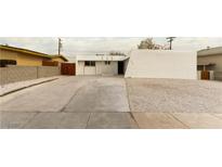 White single story home with a landscaped front yard and long driveway at 257 Colleen Dr, Las Vegas, NV 89107