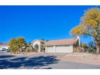 Single-story house with a three-car garage and desert landscaping at 6185 N Conquistador St, Las Vegas, NV 89149