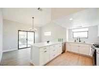 Renovated kitchen features white shaker cabinets, quartz countertops, and stainless steel appliances at 2764 Carnation Ln # 0, Henderson, NV 89074