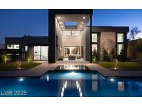 Modern home exterior featuring a pool and reflecting pool with a courtyard entrance and a well-lit exterior at 4377 Cameron Brook Ct, Las Vegas, NV 89129