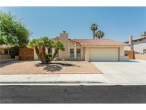 Single-story home with a landscaped front yard, attached garage, and neutral color scheme at 911 Pescados Dr, Las Vegas, NV 89123