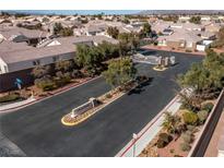 Community entrance featuring manicured landscaping, decorative signage, and a secure gate, with well-maintained homes visible beyond at 1069 Appleblossom Time Ave, North Las Vegas, NV 89031