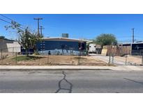 Ranch style home with a blue exterior, fenced yard, and driveway at 1901 Belmont St, North Las Vegas, NV 89030