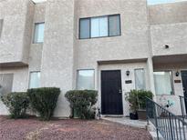 Two story stucco townhouse with dark brown door, landscaping, and walkway at 2686 Ruthe Duarte Ave, Las Vegas, NV 89121