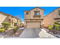Two-story house with beige exterior, attached garage, and landscaped front yard at 3448 Quiet Pueblo St, North Las Vegas, NV 89032