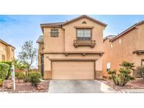 Charming two-story home with a tan stucco exterior and a well-maintained front yard in a suburban neighborhood at 3448 Quiet Pueblo St, North Las Vegas, NV 89032