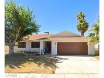 Single story home with brown garage door and landscaped yard at 4457 Rita Dr, Las Vegas, NV 89121