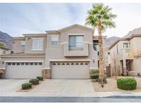 Tan two-story home with two-car garage and desert landscaping at 723 Value Ridge Ave, Henderson, NV 89012