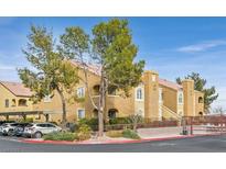 Tan two-story building with trees, parking, and gated entrance at 7950 W Flamingo Rd # 1054, Las Vegas, NV 89147