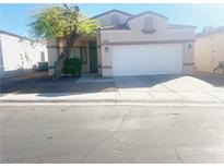 Single-story house with a white garage door and landscaping at 2132 Fred Brown Dr, Las Vegas, NV 89106