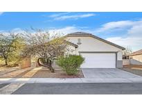 Single-story house with a white garage door and desert landscaping at 5725 Copper Sun Ct, North Las Vegas, NV 89031