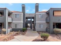 Two-story building with gray siding, red accents, and a walkway at 8600 W Charleston Blvd # 1034, Las Vegas, NV 89117