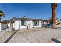 White single story home with a gravel front yard, carport, and palm tree at 909 Hassett Ave, Las Vegas, NV 89104