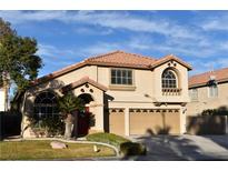 Two-story house with a three-car garage and landscaped yard at 9843 Frosty Canyon Ct, Las Vegas, NV 89183