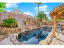 Resort-style backyard with a pool, waterfall, and covered patio at 204 Appian Way, Henderson, NV 89002