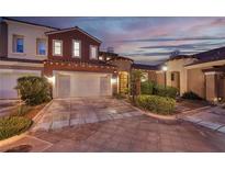 Exterior of home with two-car garage, landscaping, and sunset view at 38 Strada Principale, Henderson, NV 89011