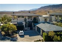 Stunning desert home featuring modern design, lush landscaping, and a spacious driveway at 4929 Summit Overlook Dr, Las Vegas, NV 89135