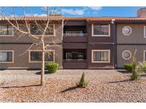 Two-story condo building features balconies, neutral colors, and desert landscaping in a well-maintained community at 5046 S Rainbow Blvd # 103, Las Vegas, NV 89118