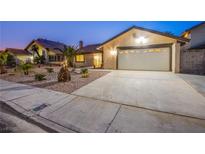 House exterior at dusk featuring a landscaped yard and attached garage at 6584 Banbridge Dr, Las Vegas, NV 89103