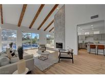 Open living area with vaulted ceilings, exposed beams, and a view of the pool at 8941 Diamond Falls Dr, Las Vegas, NV 89117