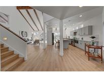 Bright open-concept living room and kitchen with vaulted ceilings and wood beam accents at 8941 Diamond Falls Dr, Las Vegas, NV 89117